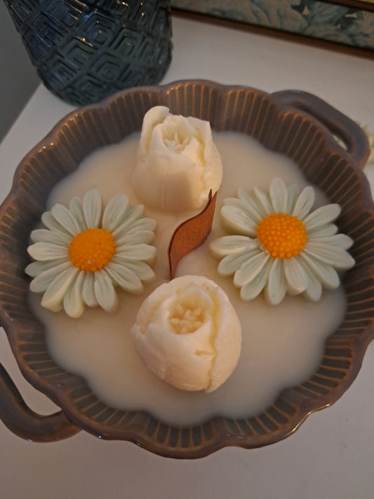 Bougie coulée à la cire d'olive avec des boutons de roses et des marguerites