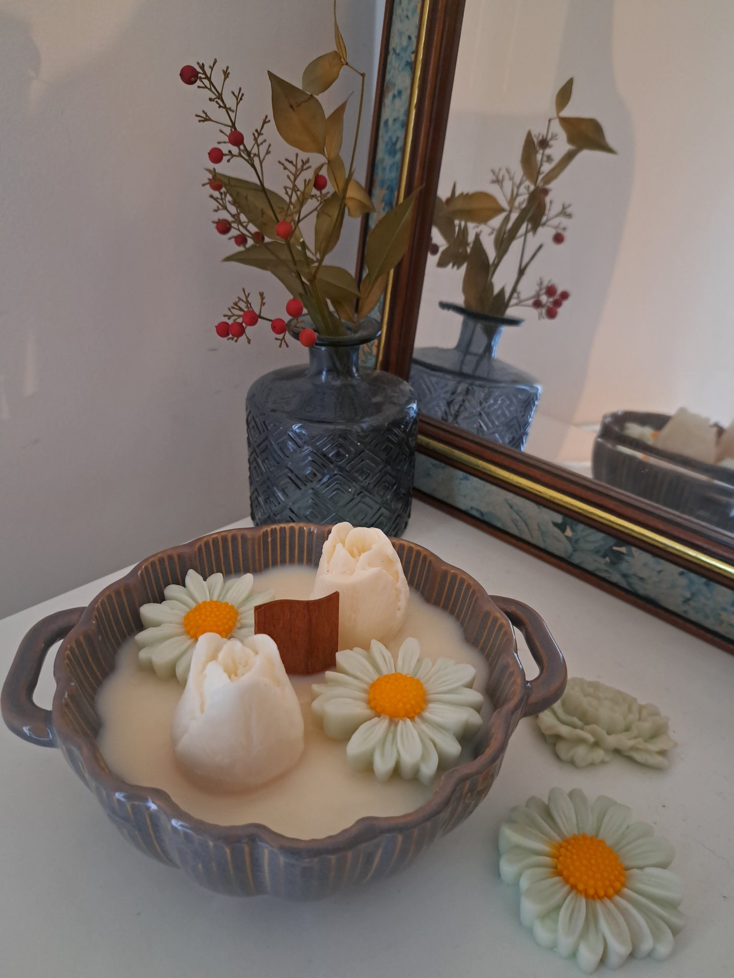 Bougie coulée à la cire d'olive avec des boutons de roses et des marguerites